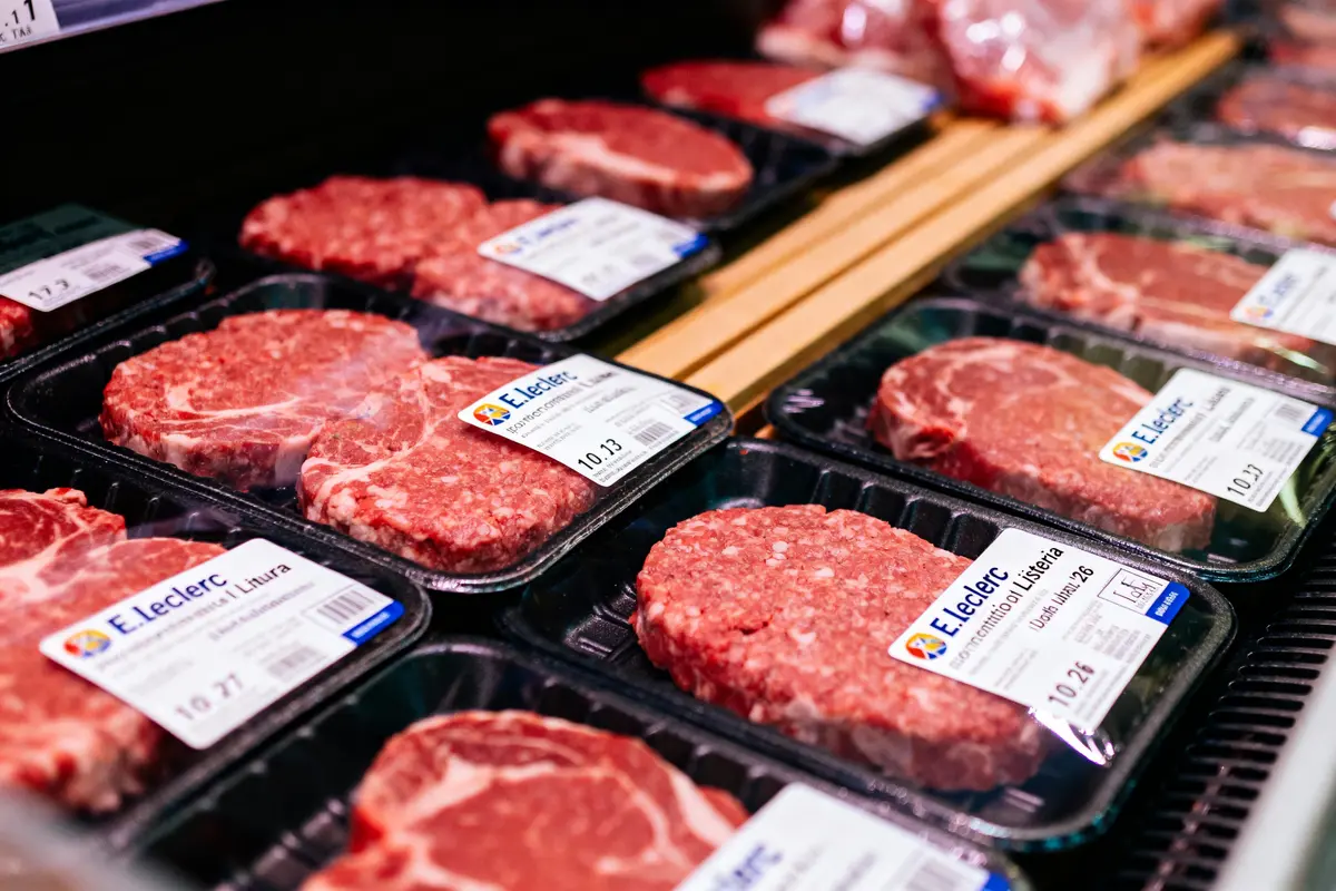 Barquettes de viande emballée avec étiquettes E.Leclerc dans un réfrigérateur de supermarché.