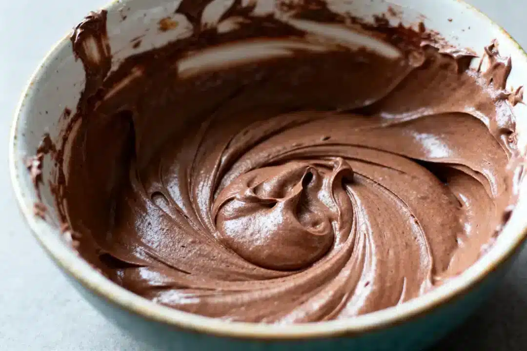 Bol rempli de pâte au chocolat crémeuse et lisse, prêt pour cuisson.