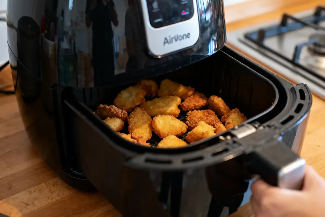 Pommes de terre croustillantes dorées dans une airfryer sur un plan de travail cuisine