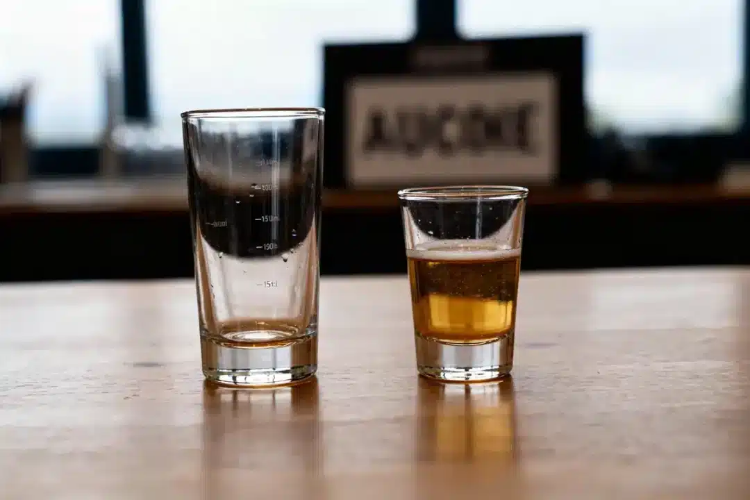Deux verres gradués sur une table, 15 cl en ml visible sur l'un.