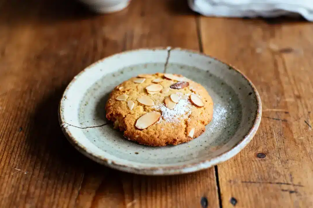 Biscuit aux amandes doré sur assiette rustique en céramique sur une table en bois