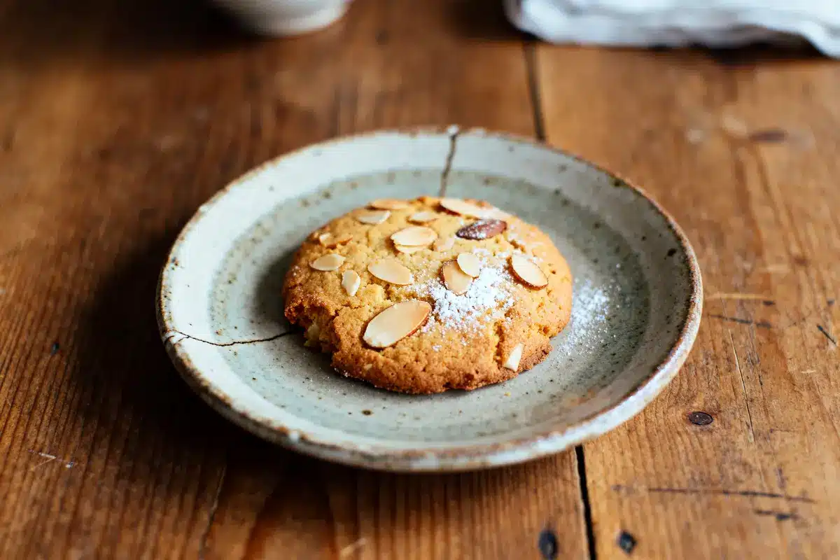 Biscuit aux amandes doré sur assiette rustique en céramique sur une table en bois