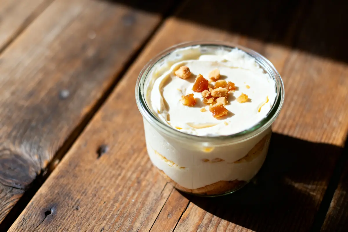 Dessert gourmand en verrine avec crème Mont-Blanc et morceaux de biscuits sur table bois