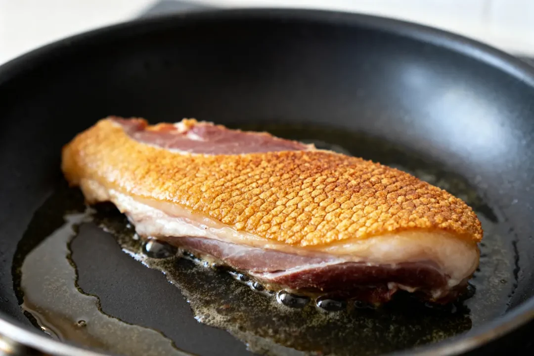 Magret de canard doré en cuisson à la poêle dans une poêle chaude