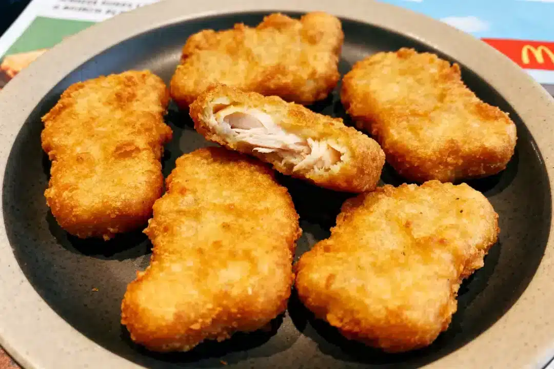 Assiette avec plusieurs nuggets de McDo dorés et croustillants, dont un coupé en deux