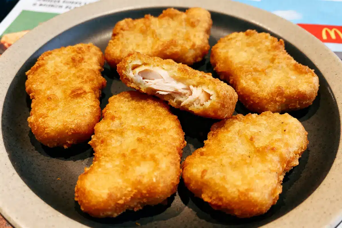 Assiette avec plusieurs nuggets de McDo dorés et croustillants, dont un coupé en deux