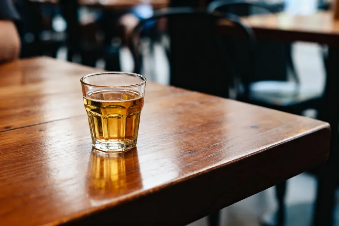 Verre de boisson sur table en bois dans un café, 25 cl en liquide.