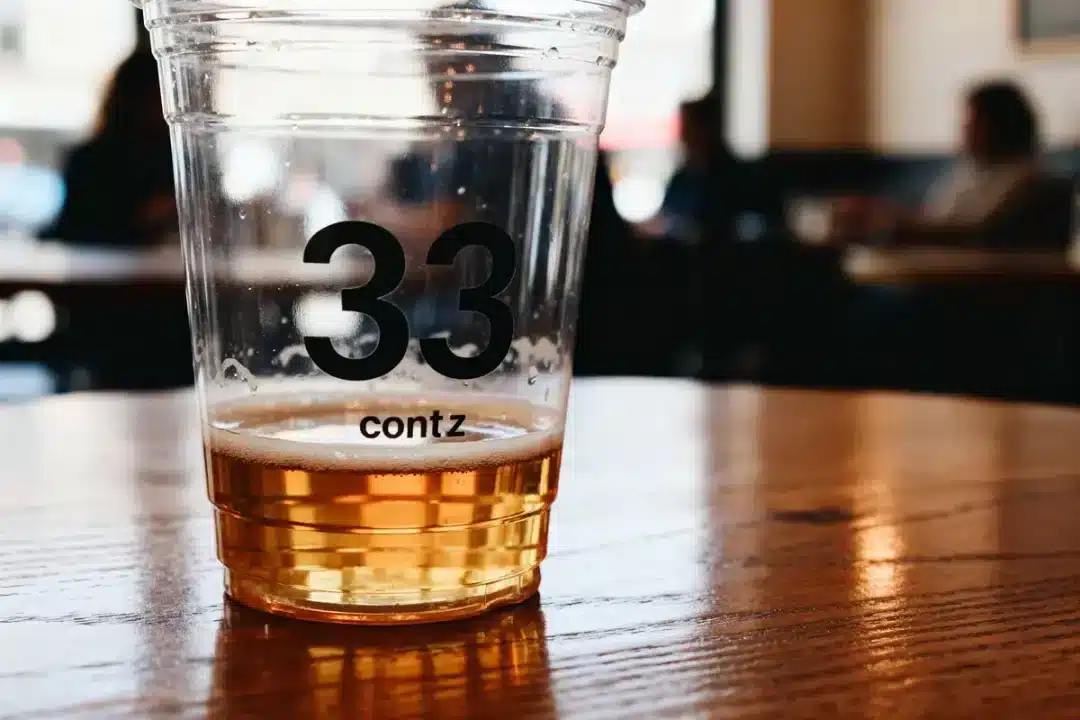 Gobelet contenant une boisson de 33 cl en millilitres posé sur une table boisée