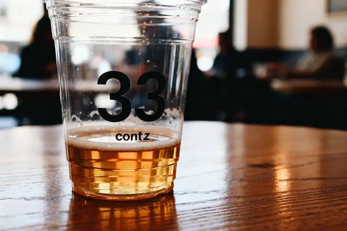 Gobelet contenant une boisson de 33 cl en millilitres posé sur une table boisée