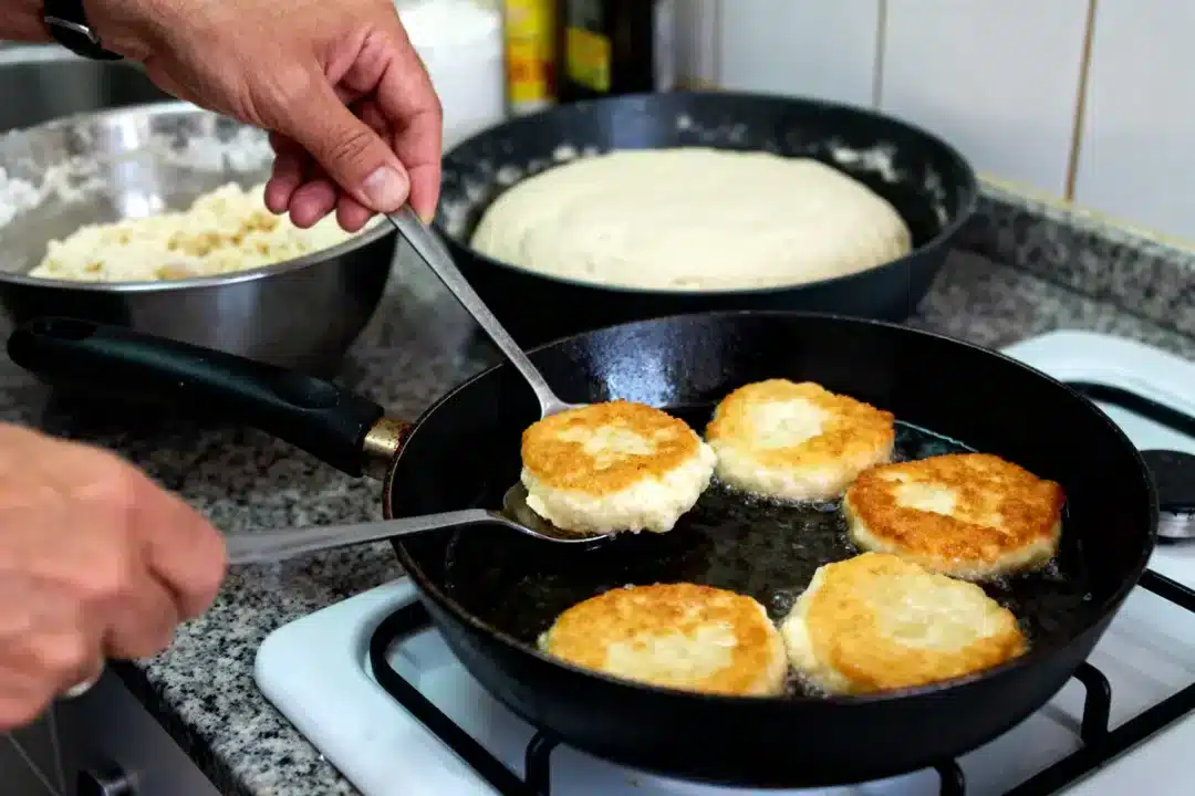 Cuisson de beignets dorés dans une poêle pour recette de bottereaux savoureuse