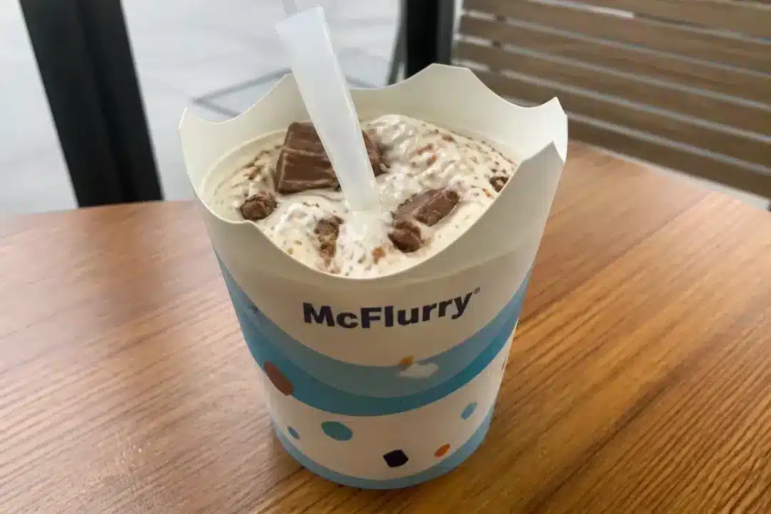 Gobelet de glace McFlurry garnie de morceaux de chocolat sur une table en bois