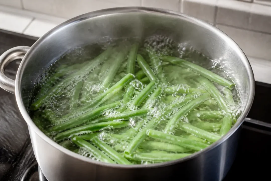 Haricots verts dans une casserole pendant leur cuisson à l'eau sur la cuisinière
