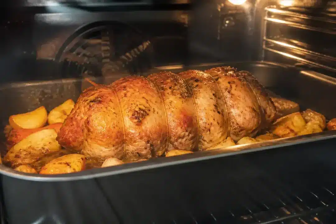 Rôti de porc au four entouré de pommes de terre, pour un moelleux optimal.
